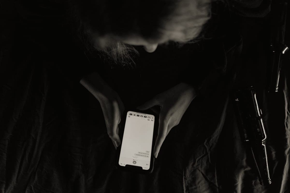A phone face down on a table beside a set of keys