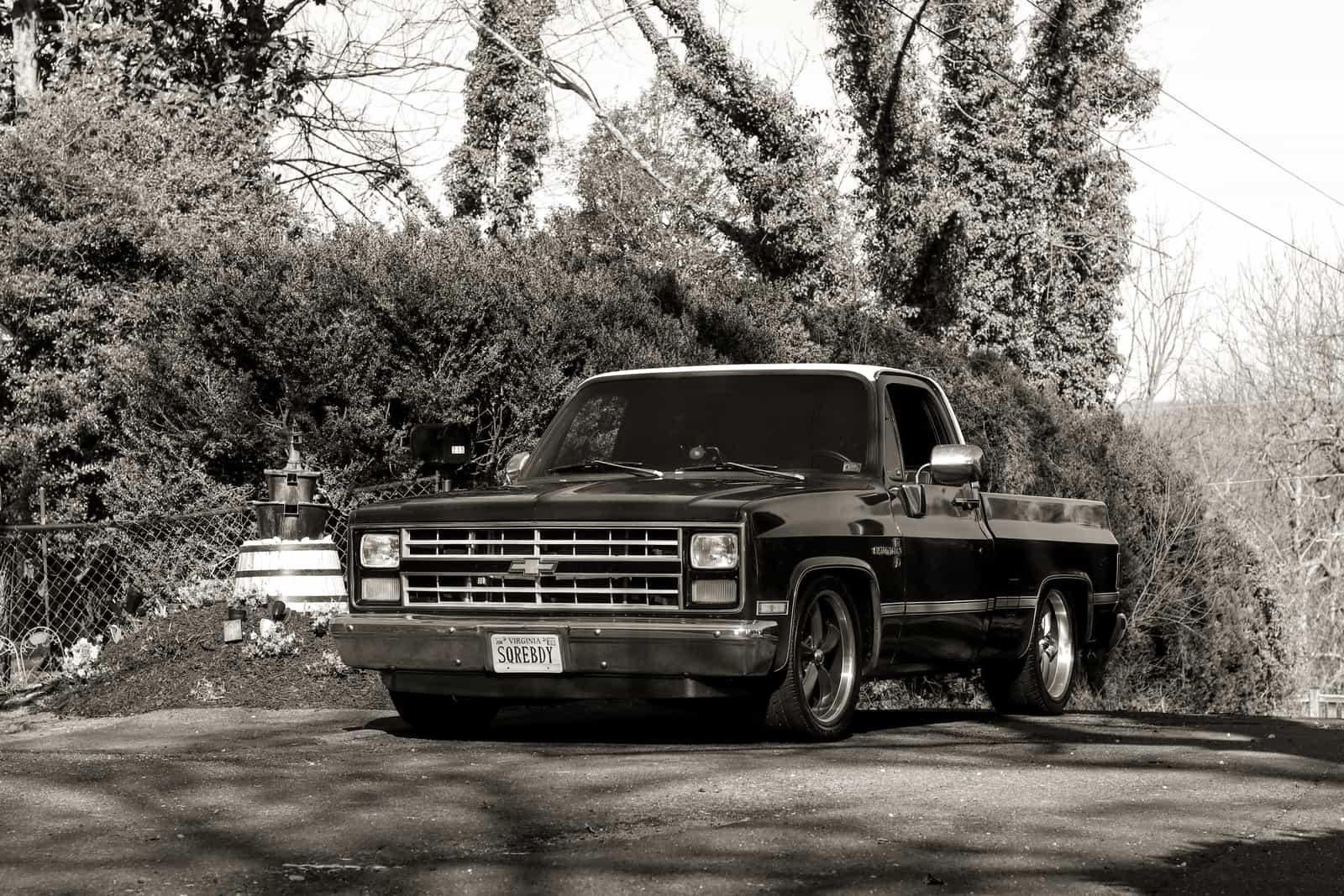 A pickup truck parked on a gravel driveway at dusk